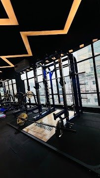 Squat racks lined up with floor-to-ceiling windows